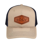 Abu Garcia Sölv Trucker Cap med beige front og skygge, marineblåt net og læderpatch med Sölv-logo.